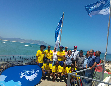 Pictured standing from left to right are: Jayson Fortuin (Life guard), Ntokozo Sibiya (Life guard), Madeleine Coetzee, Luthando Mamani (Life guard), Desmond Lakey (Area Manager: Kleinmond), Lauren Rainbird (Horticulturist), Gerrit Oosthuizen (Coca-Cola Depot Manager), Cllr Rudolph (Deputy Mayor), Cllr Phillipus Appelgrein (Mayco Member: Protection and Management services), Sandiso Magaba (Wessa)  Front row: Mondli Mthethwa, Sikhumbuzo Mtolo, Lucky Dlamini, Melusi Bulose, and Nhlanhla Tau (Life guards)