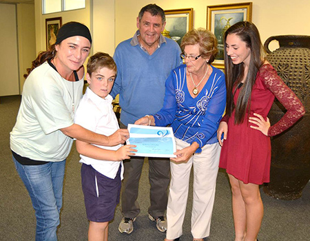  1: 8-year old, Jack Kastner (second left) an attendee of the Butterfly Centre in Stanford, accepts an allocation certificate from Overstrand Mayor, Nicolette Botha-Guthrie (second right) while mom Jami Yeats-Kastner (first left) and grandad Andrew Herriot (centre) look on proudly. Also in attendance was Miss Teen Commonwealth SA finalist, Alissa Coetze (first right) who brought the Centre’s efforts on special needs education to the Mayor’s attention.